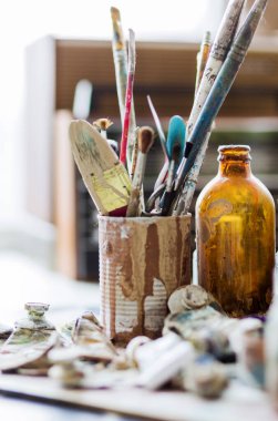 Kullanılmış boya fırçaları ve tüplerdeki yağlı boyalar masanın üzerinde..