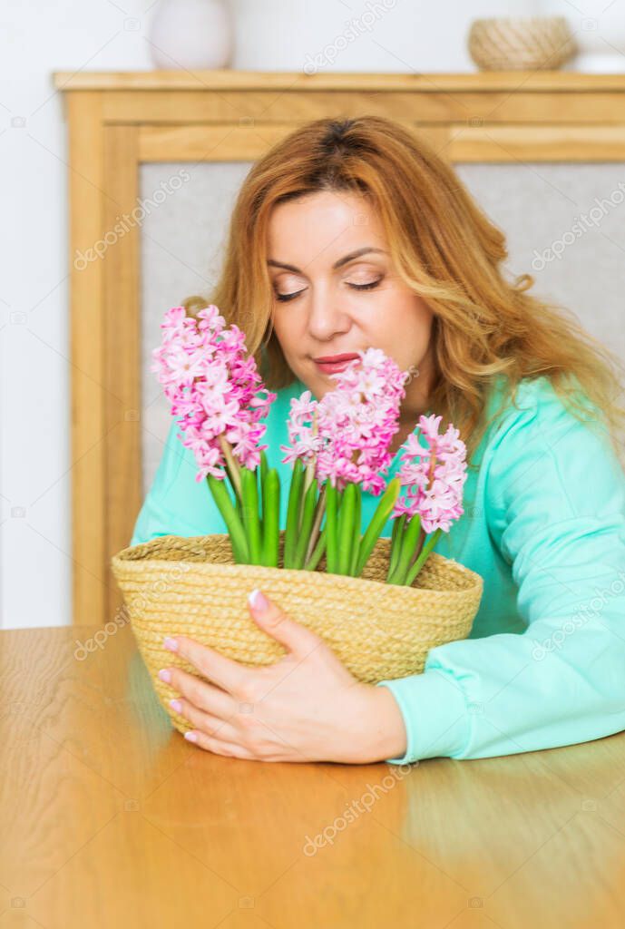 Beautiful woman in green home suit posing with hyacinth flower. Peace of mind and serenity concept