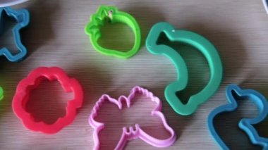 Çocuklar masanın üzerinde çok renkli plastik kalıplar var.