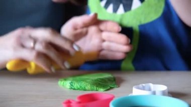 Anne çocuğa hamuru nasıl çıkaracağını gösterir.