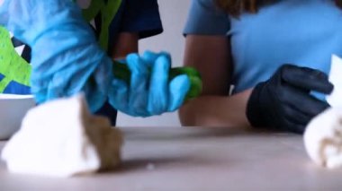 Anne ve çocuk hamuru elleriyle çeviriyorlar.