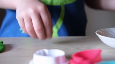 Çocuk renkli hamurdan bir zanaat yapıyor.