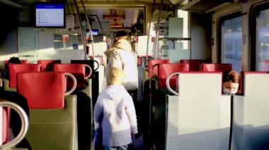 Kızıyla birlikte tren vagonunda yürüyen genç bir kadın, 20 Aralık 2021 'de Minsk, Belarus' ta bir yer arıyor.