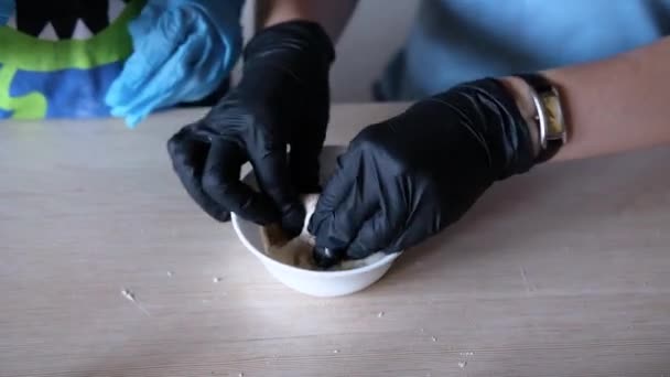 Женщины руки в перчатках месят тесто — стоковое видео