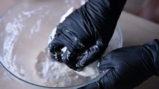 Οι γυναίκες χέρια σε μαύρα γάντια ζυμώνουν τη ζύμη — Αρχείο Βίντεο