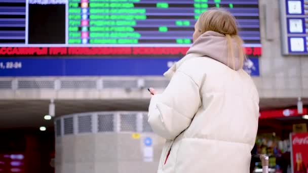 Femme regardant l'arrivée à bord et vérifiant le vol — Video
