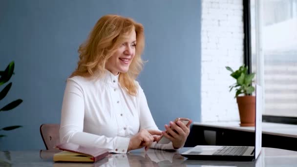 Krásná žena podnikatel sedí v kanceláři a používá mobilní telefon — Stock video