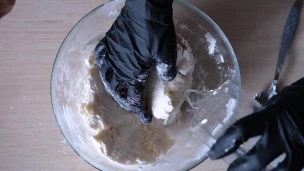 Ženy ruce v černých rukavicích hnětou těsto — Stock video