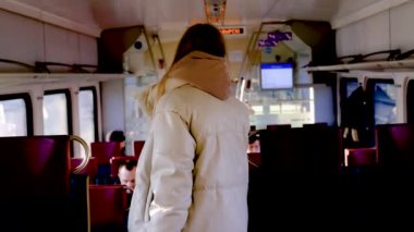 Tren vagonunda genç bir kadın evini arıyor.