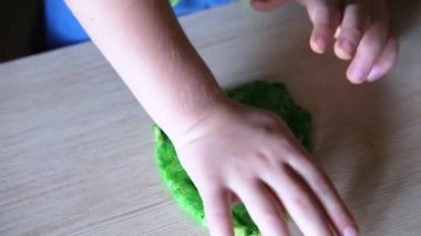 Çocuk hamuru şekillendirmek için plastik küf kullanıyor.