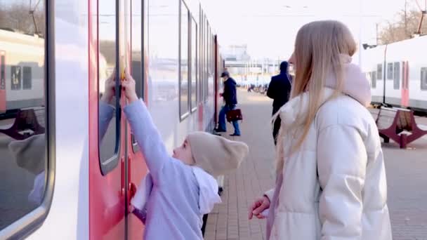 Anne ve kızı kapıdaki düğmeye basarak tren vagonuna biniyorlar. — Stok video