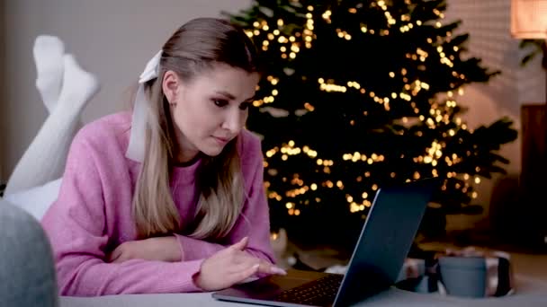Ung vacker kaukasiska kvinna som använder laptop på soffan — Stockvideo