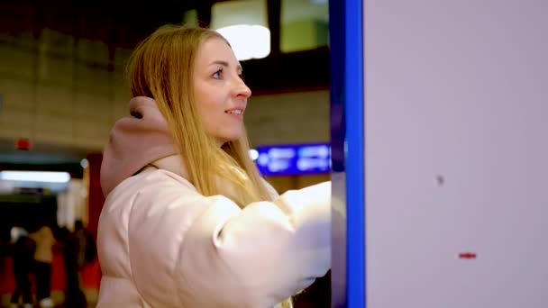 穿着夹克买火车或地铁车票的年轻微笑的女人 — 图库视频影像