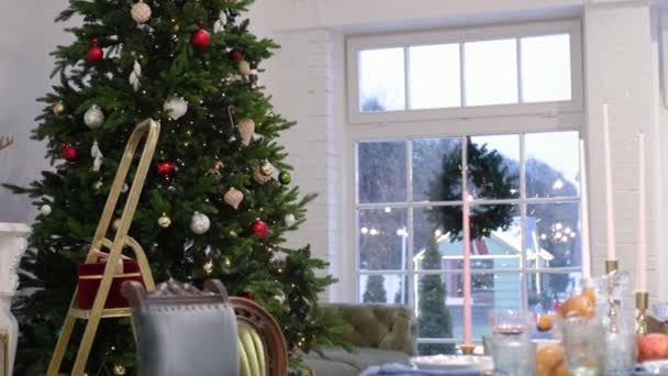 The room is decorated with Christmas decor and its snowing outside the window — Stock Video