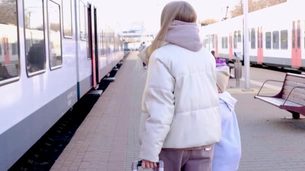 Mutter und Tochter gehen am Bahnsteig entlang und suchen nach ihrem Waggon - Minsk, Weißrussland, 20. Dezember 2021 — Stockvideo