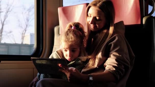 Moeder helpt haar dochter tekenen een beeld terwijl ze op de trein — Stockvideo