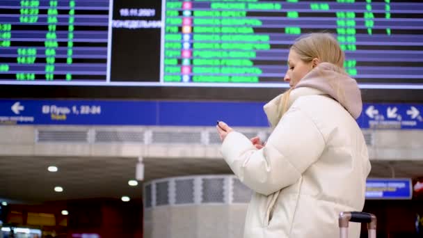 Femme regardant l'arrivée à bord et vérifiant le vol — Video