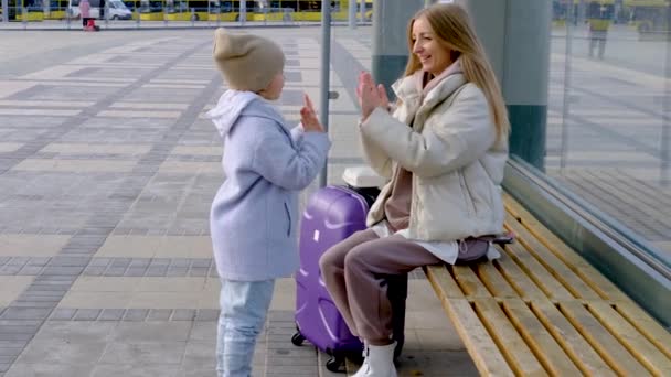 Mamãe e filha estão sentados na parada de ônibus — Vídeo de Stock