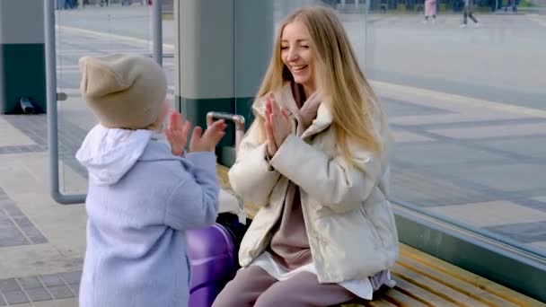 Mutter und Tochter sitzen an der Bushaltestelle — Stockvideo