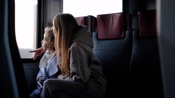 Mamma e figlia cavalcare in un treno vicino alla finestra — Video Stock