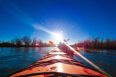 Sakin bir kış gününde nehir manzarası. Tuna Nehri 'nde kırmızı kano yayı. Soğuk mevsimde kano.