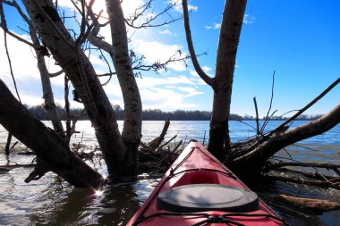 Sakin bir kış gününde nehir manzarası. Tuna Nehri 'nde kırmızı kano yayı. Soğuk mevsimde kano.