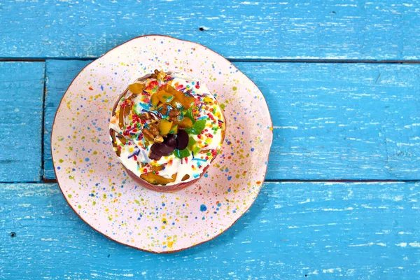 Mavi kırsal ahşap arka plan manzaralı renkli kremalı lezzetli paskalya pastası. Metin için boşluk. Mutlu Paskalya konsepti, düz yat..