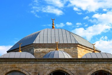Bulutlu mavi gökyüzüne karşı antik bir caminin çatısı ve kubbesi