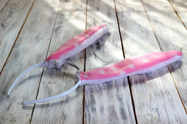 Beyaz ahşap arka planda pembe tavşan kulağı şeklinde saç halkası