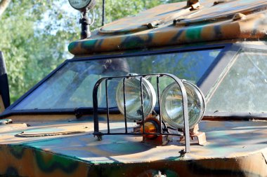 Kamuflaj renginde araba amfibisinin far ve ön camı. Yakın çekim.