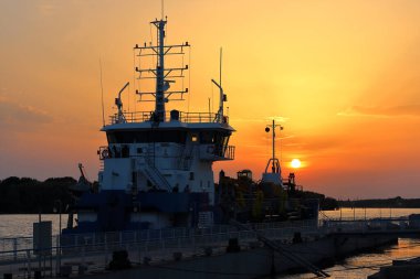 Gün batımında iskeleye yakın bir gemi.