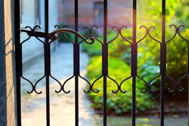 Gün batımında işlenmiş demir bir kafes kapısının parçası.