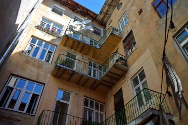 Eski pencereleri ve balkonları olan geleneksel bir ön cephe. Lviv, Ukrayna 'nın eski otantik avlusu.