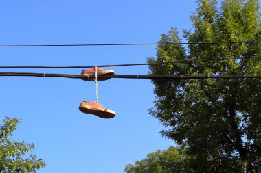 Mavi gökyüzüne doğru sarkan spor ayakkabıları