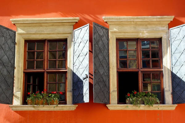 Два Старовинні Вікна Залізними Віконницями Червоній Стіні Прикрашені Квітами — стокове фото