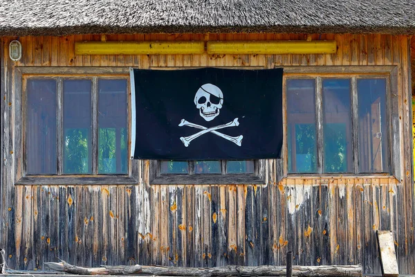 Деревянная Хижина Крышей Сухой Камыша Берегу Реки Черным Пиратским Флагом — стоковое фото