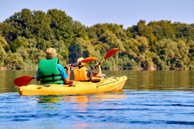Baba ve oğul yazın Tuna nehrinde kayak yapıyorlar.