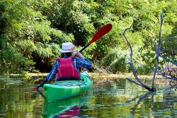 Woman Elegant Canotier Paddling Green Kayak Wilderness River Overgrown Duckweed — Stock fotografie