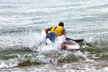 Man starts on SUP from the shore. Sea beach start on rowing competitions on SUP (stand up paddle boarding)