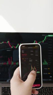 Borsa çizelgeleri olan bir telefonun yakın çekimi. grafikli bir dizüstü bilgisayarın arka planına karşı