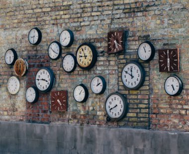 Eski tuğla duvarda antika saatler.