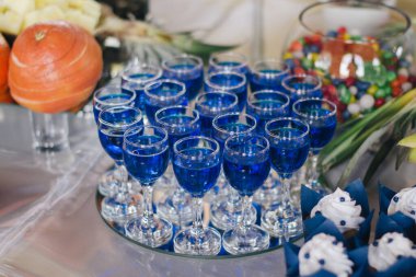 Büfe masasında mavi alkol bardakları