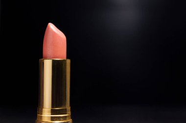 Golden Lipstick for Pink Color, in Black background for Advertising.