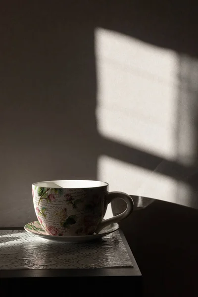 Grande tasse sur une table avec des ombres profondes. — Photo