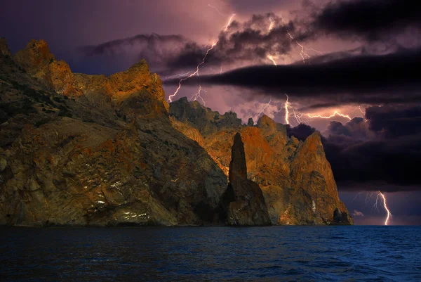 Karadeniz 'in kayalık kıyılarında şimşekler çakıyor, Karadeniz kıyısında Koktebel yakınlarında bir fırtına var. Karadağ dağ sırası. Çarpıcı bir ruh hali..