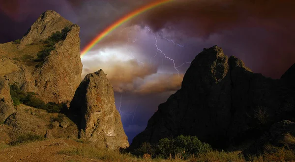 Karadeniz 'in kayalık kıyılarında gökkuşağı ve şimşek, Doğu Kırım' daki Koktebel yakınlarındaki Karadağ dağ sırasının kayalık uçurumlarındaki fırtınanın çarpıcı görüntüsü.. 