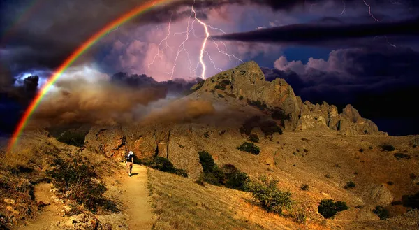 Karadeniz 'in kayalık kıyılarında gökkuşağı ve şimşek, Doğu Kırım' daki Koktebel yakınlarındaki Karadağ dağ sırasının kayalık uçurumlarındaki fırtınanın çarpıcı görüntüsü.. 