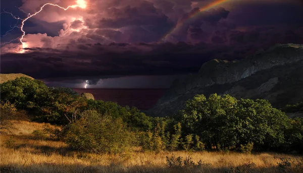 Karadağ 'ın kayalarının üzerinde şimşek çakıyor. Karadeniz kıyısı, Doğu Kırım, dağlarda çarpıcı bir fırtına manzarası, yıldırımlar ve parıltılarla