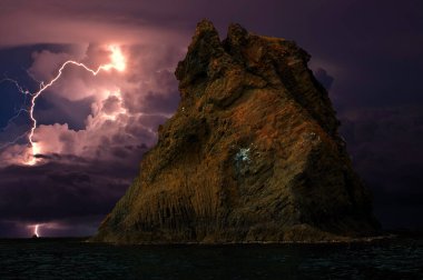 Karadeniz kıyısında şimşekler çakıyor, Kırım. Feodosiya ve Koktebel yakınlarındaki Karadeniz, Doğu Kırım 'ın sığ sularında, su ve kıyı kayaları üzerinde şimşekler çakıyor.