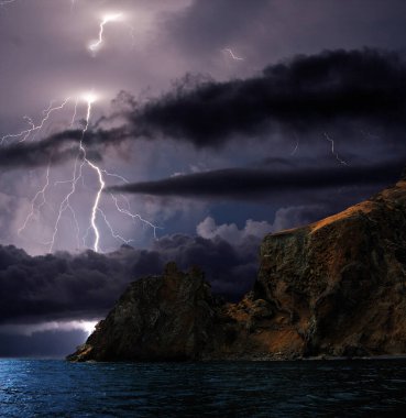 Karadeniz kıyısında şimşekler çakıyor, Kırım. Feodosiya ve Koktebel yakınlarındaki Karadeniz, Doğu Kırım 'ın sığ sularında, su ve kıyı kayaları üzerinde şimşekler çakıyor.